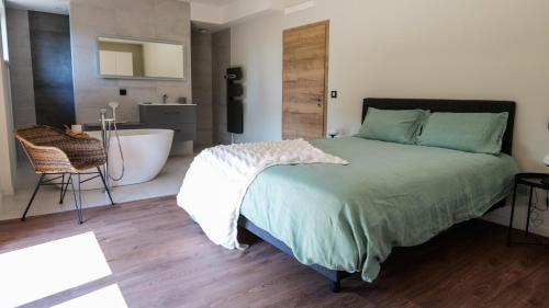 ein Schlafzimmer mit einem Bett und ein Badezimmer mit einer Badewanne in der Unterkunft Maison 21 in Zutzendorf
