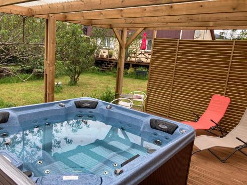 a hot tub on a deck with a chair at petite chambre vue piton des neiges Les Capucines du volcan in La Plaine des Cafres