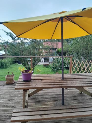 a yellow umbrella sitting on a wooden deck at petite chambre vue piton des neiges Les Capucines du volcan in La Plaine des Cafres