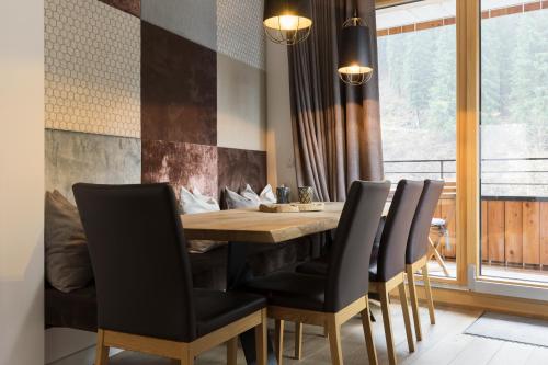 a dining room with a wooden table and chairs at Aparthotel Herzblick GmbH in See