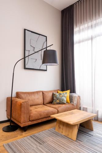 a living room with a brown couch and a table at Apartments with private parking & terrace in Jūrmala