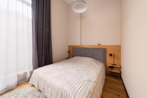 a bedroom with a bed and a large window at Apartments with private parking & terrace in Jūrmala