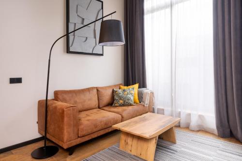 a living room with a brown couch and a table at Apartments with private parking & terrace in Jūrmala