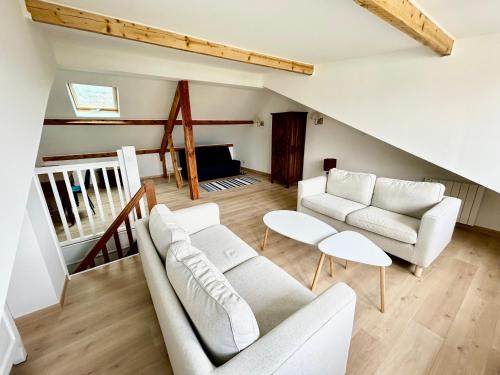 Il comprend un salon doté d'un mobilier blanc et d'un escalier. dans l'établissement Voyage à Blonville, à Blonville-sur-Mer