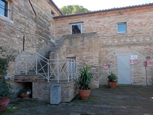 a brick building with a staircase with a dog on it at camere in Villa Luzi in Treia