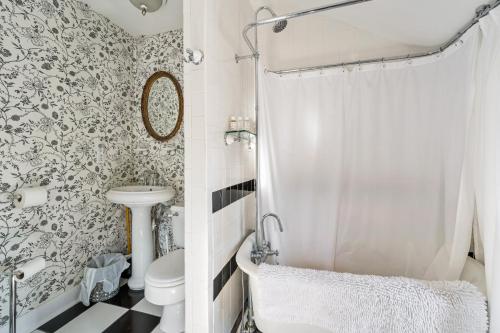 a white bathroom with a toilet and a shower at The Gables of Rhinebeck in Rhinebeck