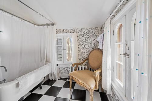 baño con silla y suelo a cuadros en blanco y negro en The Gables of Rhinebeck, en Rhinebeck