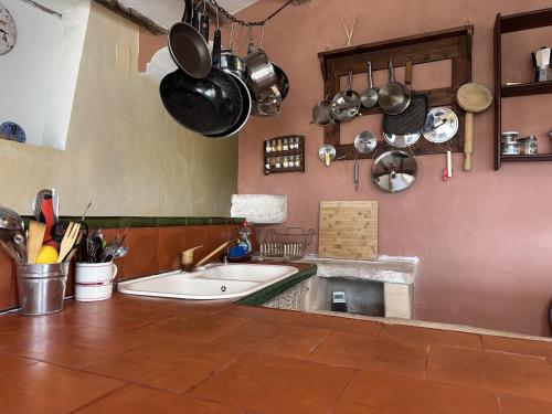 uma cozinha com um grande lavatório e panelas e frigideiras em Escapada mágica en El Carmen em Aigues