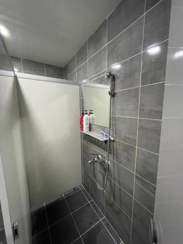 y baño con ducha y espejo. en Yesjun Guest house en Jeju