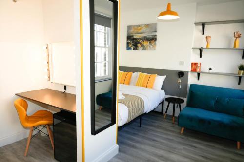 a bedroom with a bed and a desk and a blue couch at Camden Town Self Check-in Luxury Rooms in London