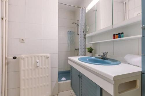 ein Badezimmer mit einem blauen Waschbecken und einer Dusche in der Unterkunft ruim appartement aan zee in Ostende