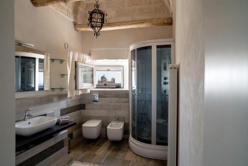 La salle de bains est pourvue d'un lavabo, de toilettes et d'un miroir. dans l'établissement Casa vacanza - Kora Home, à Ostuni