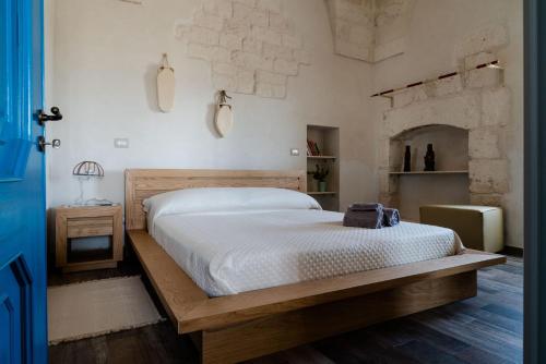 - une chambre avec un lit avec un cadre en bois et une cheminée dans l'établissement Casa vacanza - Kora Home, à Ostuni