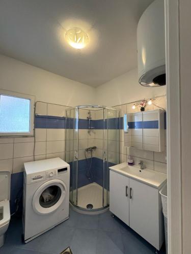 a bathroom with a washing machine and a washer at Mimosa Luxury Apartment in Sarandë
