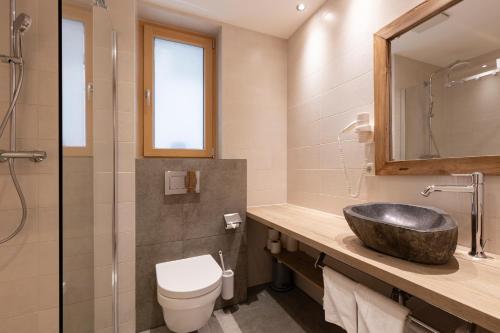 a bathroom with a sink and a toilet at Aparthotel Herzblick GmbH in See