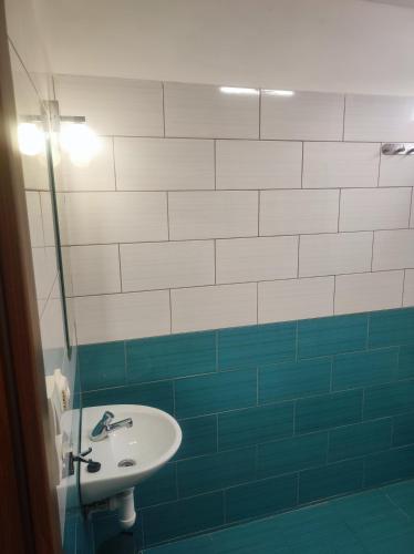 a bathroom with a sink and blue and white tiles at Pronájem dřevěného mobilheimu Štít in Chlumec nad Cidlinou