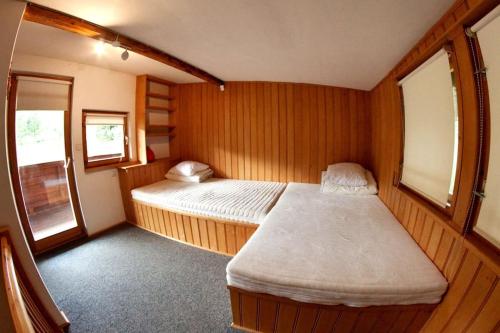 a small bedroom with a bed in a wooden room at Basen Przesieka - drewniany dom z dużym stawem kąpielowym in Przesieka
