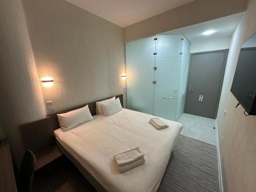 a bedroom with a bed with two towels on it at City Centre Hotel in Tashkent
