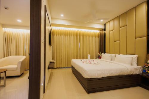 ein Hotelzimmer mit einem Bett und einem Stuhl darin in der Unterkunft Meghalaya Hotel in Visakhapatnam