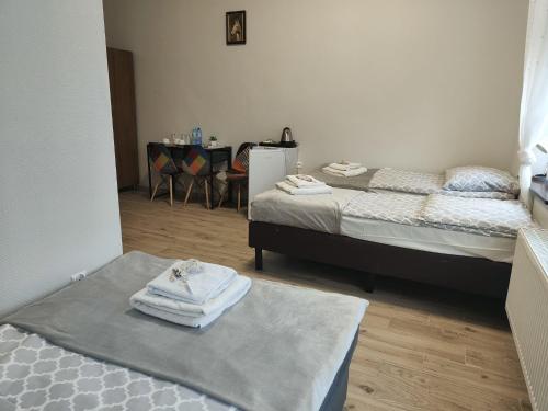 una habitación con 2 camas y una mesa con toallas en Pałac pod Bocianim Gniazdem, en Runowo