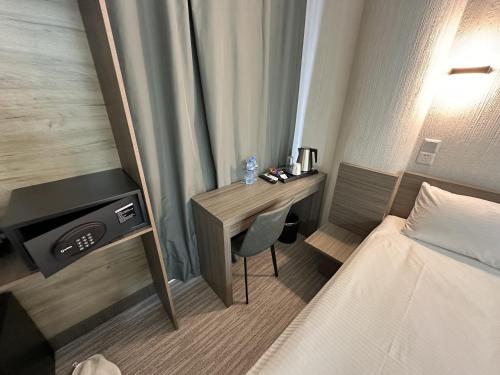 a hotel room with a desk and a bed at City Centre Hotel in Tashkent