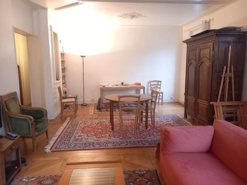 un salon avec un canapé, une table et des chaises dans l'établissement Large and cosy, Paris-Ouest, à Levallois-Perret