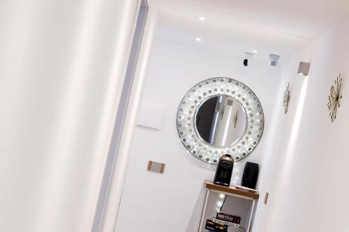a mirror on a white wall next to a shelf at Edahouse in Salerno