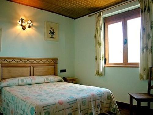 a bedroom with a bed and a window at Casa Rural Roblegordo in Rabanera del Pinar