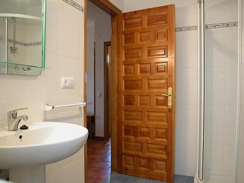 baño con lavabo y puerta de madera en Casa Rural Los Roblones, en Rabanera del Pinar