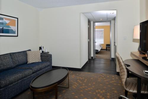 a living room with a couch and a table at Holiday Inn Hotel & Suites Overland Park-Convention Center by IHG in Overland Park