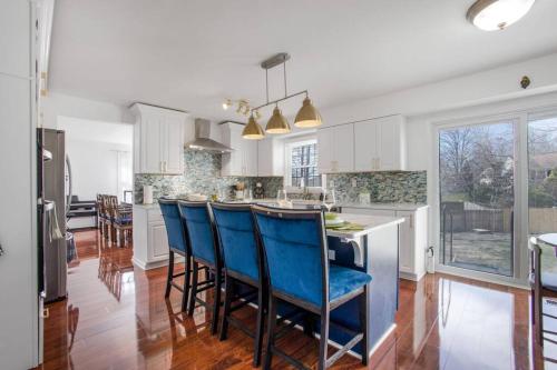 a kitchen with a island with blue chairs in it at Modern Oasis Near Washington DC in Silver Spring