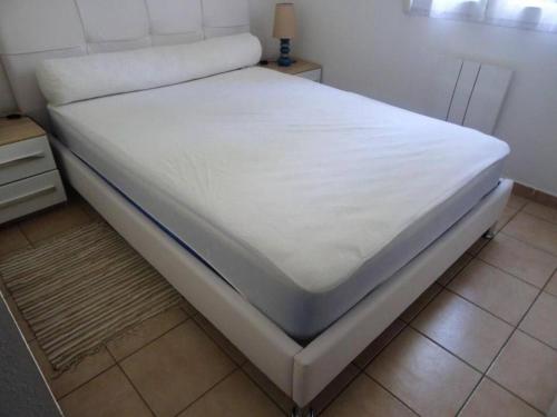 Ce lit se trouve dans un dortoir doté d'un matelas blanc. dans l'établissement Appart 4 pers résidence piscine, à Villeneuve-lès-Avignon