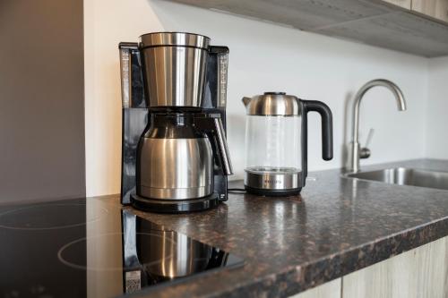 a coffee maker on a counter next to a sink at Aparthotel Herzblick GmbH in See