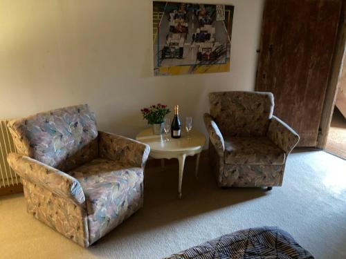 a living room with two chairs and a table at Domaine Le Sciau in Couzon