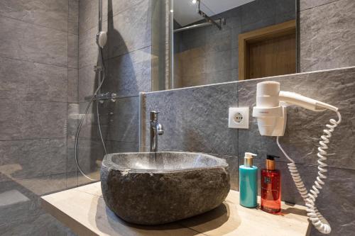 a bathroom with a stone sink and a shower at Aparthotel Herzblick GmbH in See