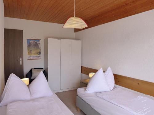 a bedroom with two beds with white pillows at Holiday Home Salzhubelweg by Interhome in Goldswil