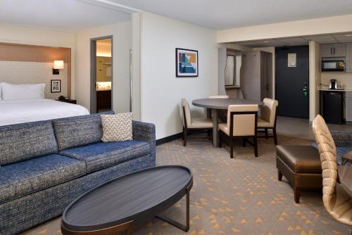 a hotel room with a couch and a bed and a table at Holiday Inn Hotel & Suites Overland Park-Convention Center by IHG in Overland Park