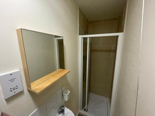 a bathroom with a mirror and a shower in it at Immaculate 2-Bed Duplex Apartment in Leeds in Leeds