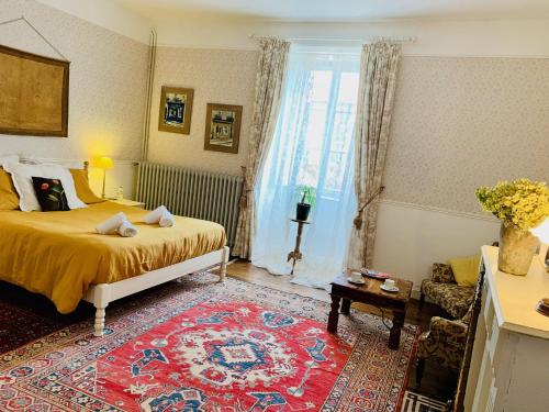 a bedroom with a bed and a living room at Maison d'Hôtes de l'Ancien Couvent des Carmes in Mortemart