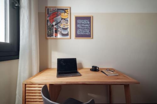 a wooden desk with a laptop on top of it at Los Olivos Apartments by Olala Homes in Seville