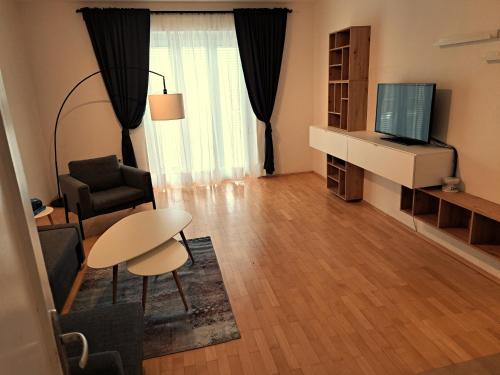 グラーツにあるFlataid Apartment Elisabethinergasseの小さなリビングルーム(テーブル、テレビ付)