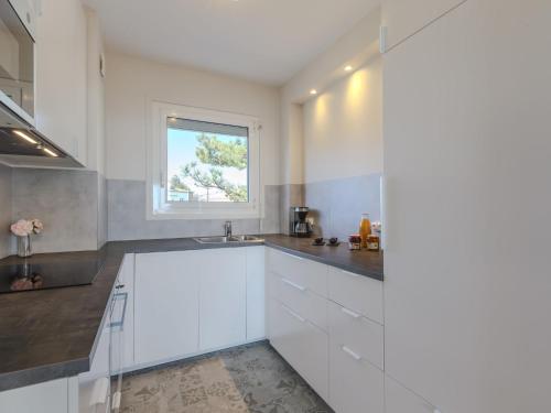 cocina blanca con fregadero y ventana en Apartment Saint Sordelin by Interhome en Pontaillac