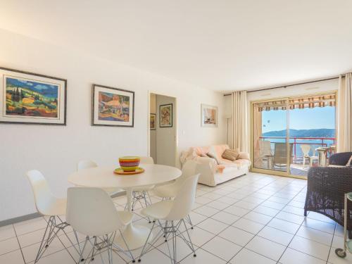 una sala de estar con una mesa y sillas en Apartment Les Mandariniers by Interhome, en Le Lavandou