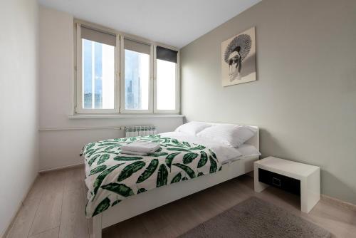 a white bedroom with a bed and a window at Comfy Flat in the City Center in Warsaw