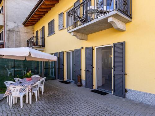 patio ze stołem i krzesłami oraz budynek w obiekcie Holiday Home Carmen by Interhome w mieście Brissago Valtravaglia