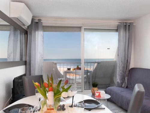 - un salon avec une table et une vue sur l'océan dans l'établissement Apartment La Calypso-6 by Interhome, à La Grande Motte