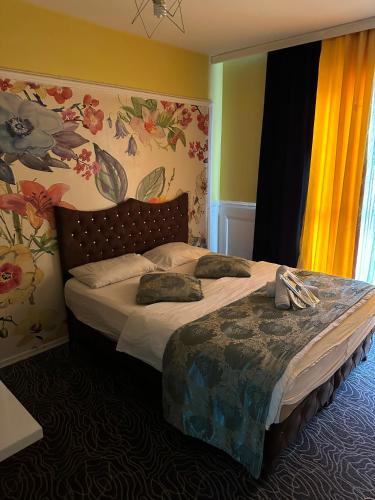 1 dormitorio con 1 cama grande con flores en la pared en Mavikapı Suit, en Estambul