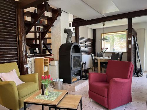 a living room with colorful chairs and a wood stove at Holiday Home Sorgenfrei by Interhome in Frankenau