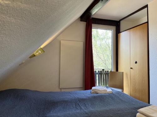 a bedroom with a blue bed and a window at Holiday Home Sorgenfrei by Interhome in Frankenau