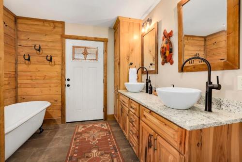 uma casa de banho com 2 lavatórios e uma banheira. em River Ranch-Secluded Outdoor Oasis em West Siloam Springs